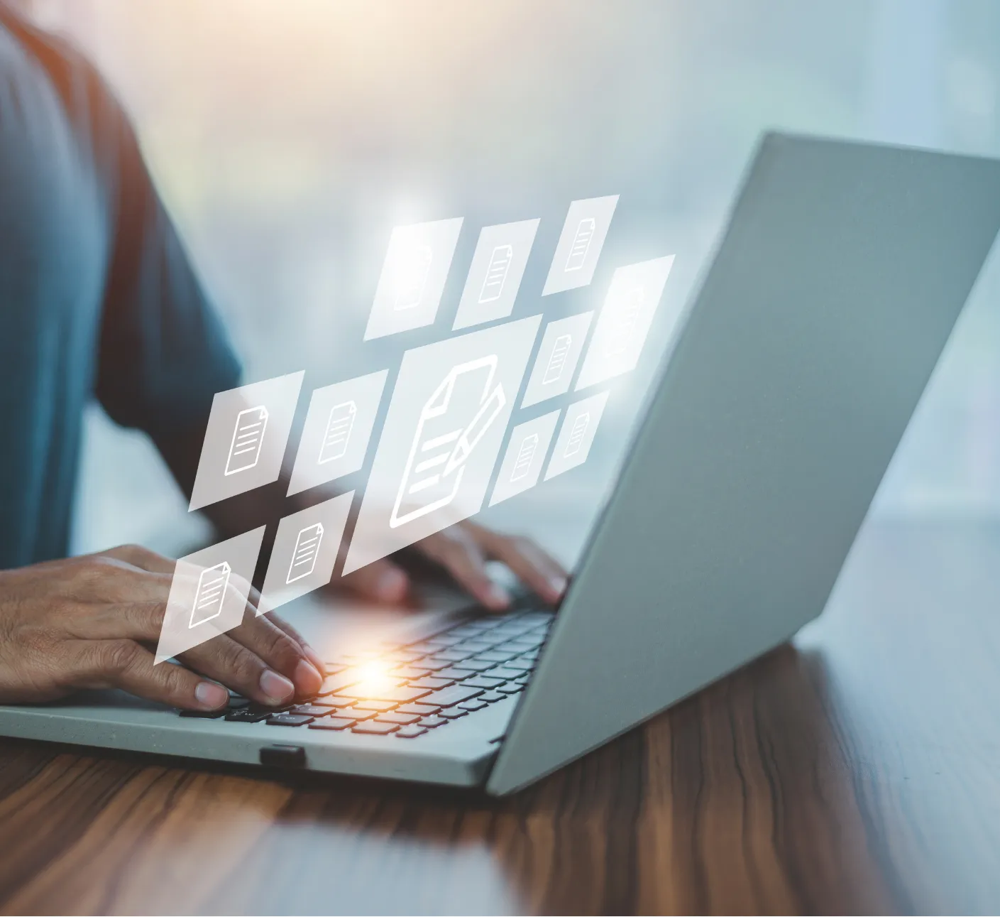 about-3 Person typing on a laptop with floating digital icons of documents above the keyboard, suggesting file management.
