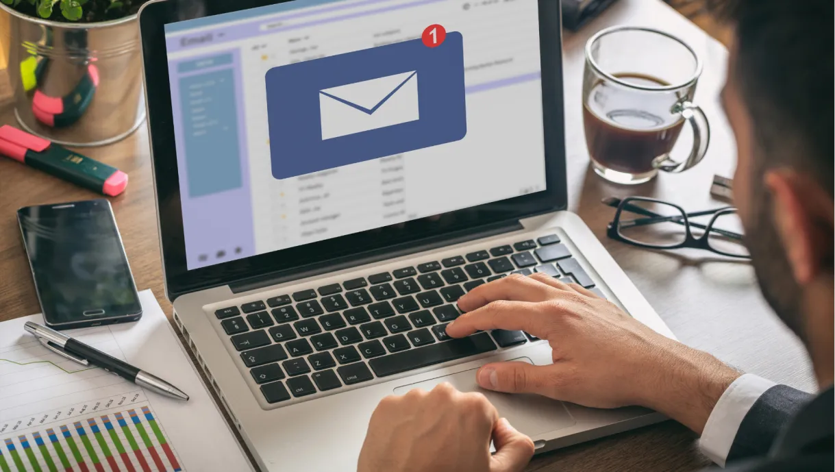 A person checks email on a laptop and sees one new message notification on the screen.